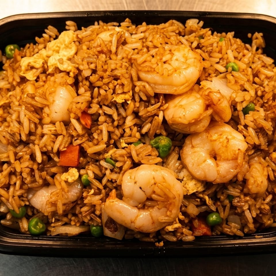 Shrimp fried rice with peas, carrots, and scrambled egg in a black takeout container.